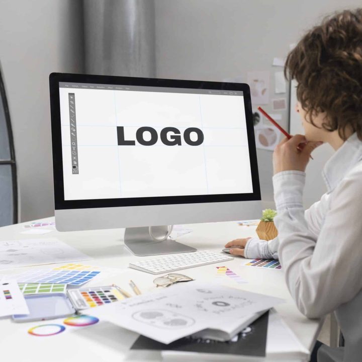logo designer working computer desktop scaled